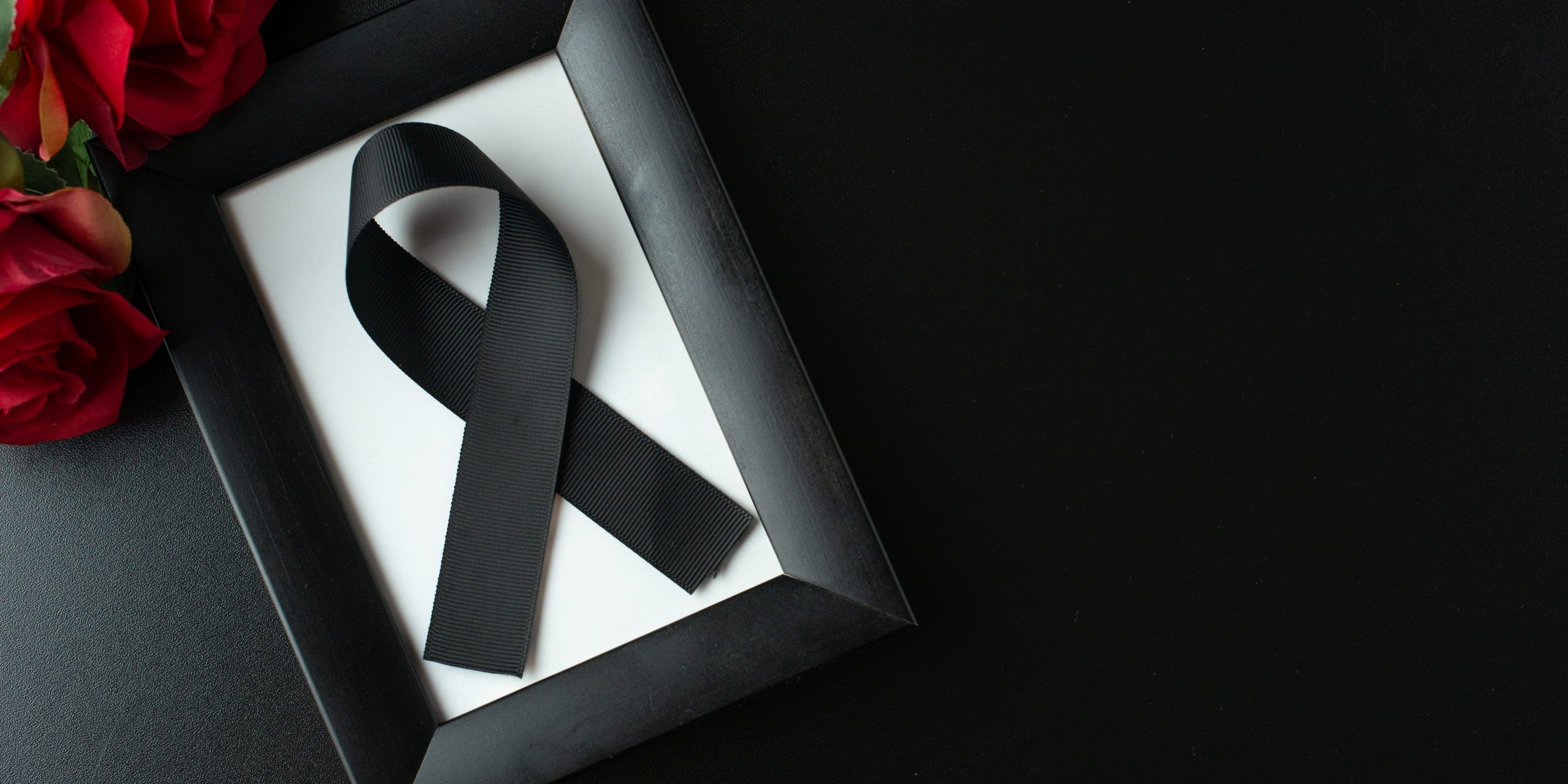 top-view-picture-frame-with-black-bow-dark-wall