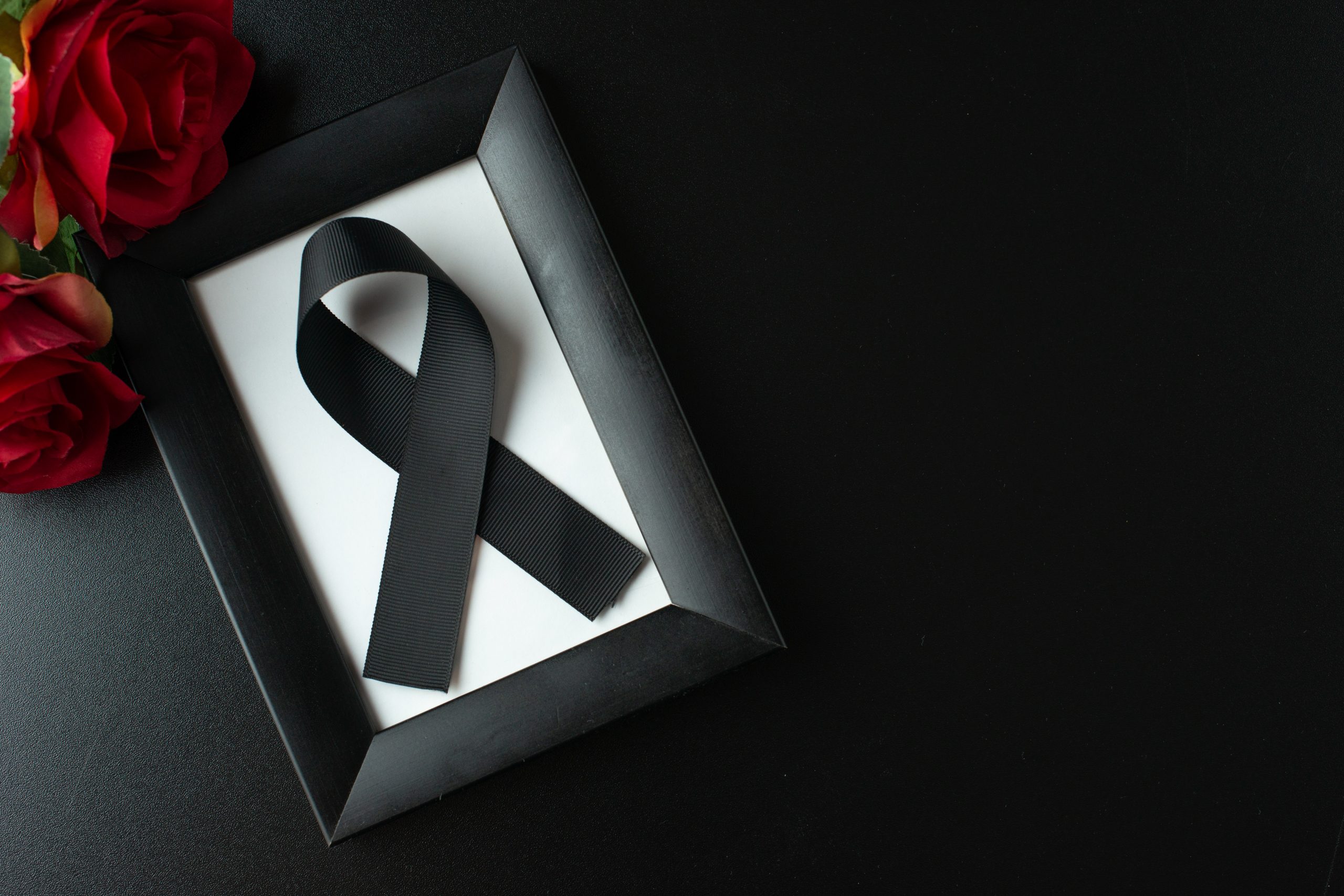 top-view-picture-frame-with-black-bow-dark-wall