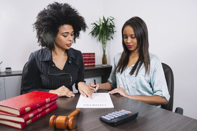 african-american-woman-pointing-document-near-lady-with-pen-table