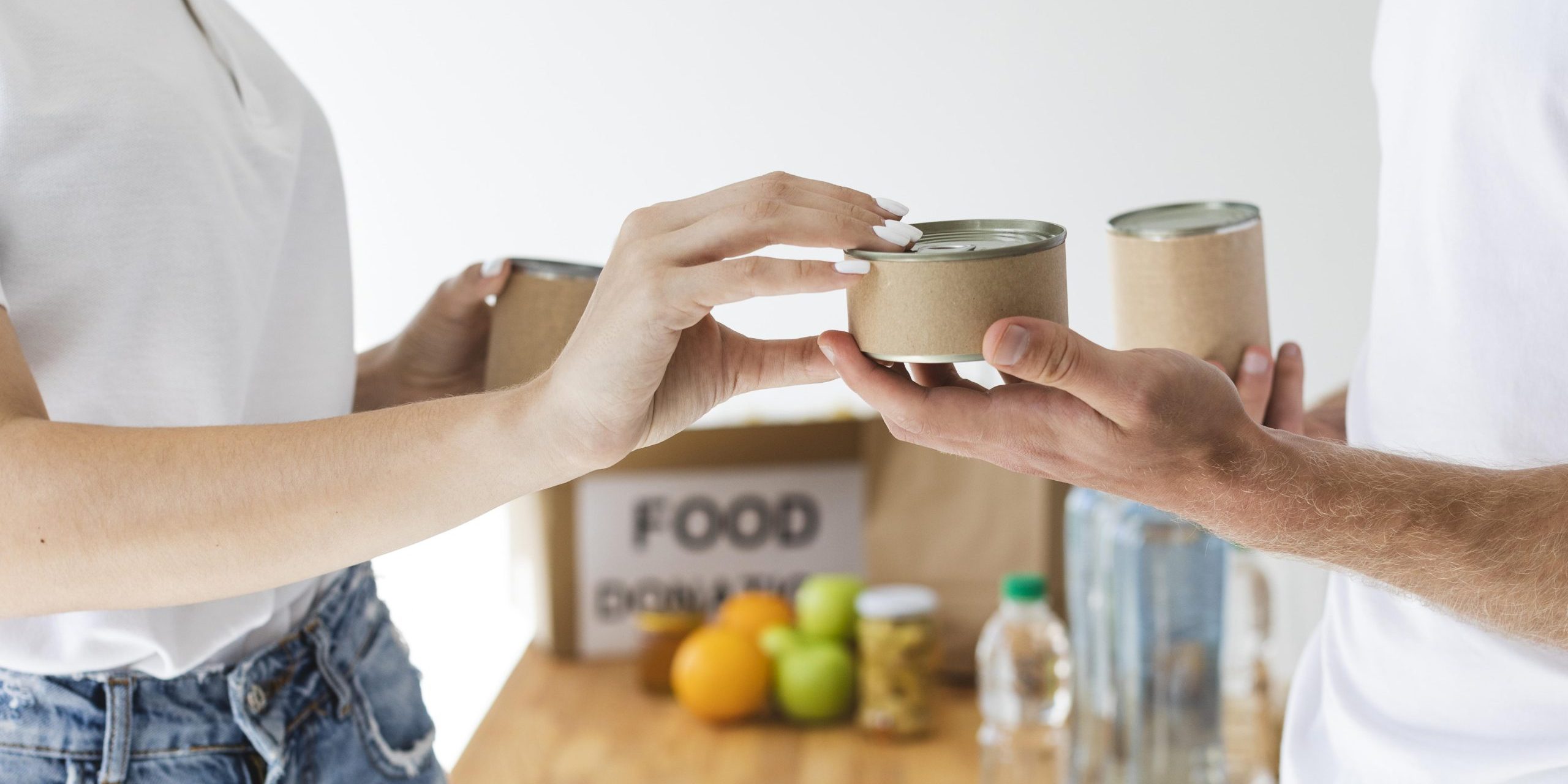 vista-lateral-de-voluntarios-trocando-latas-por-caixas-de-doacao-de-alimentos