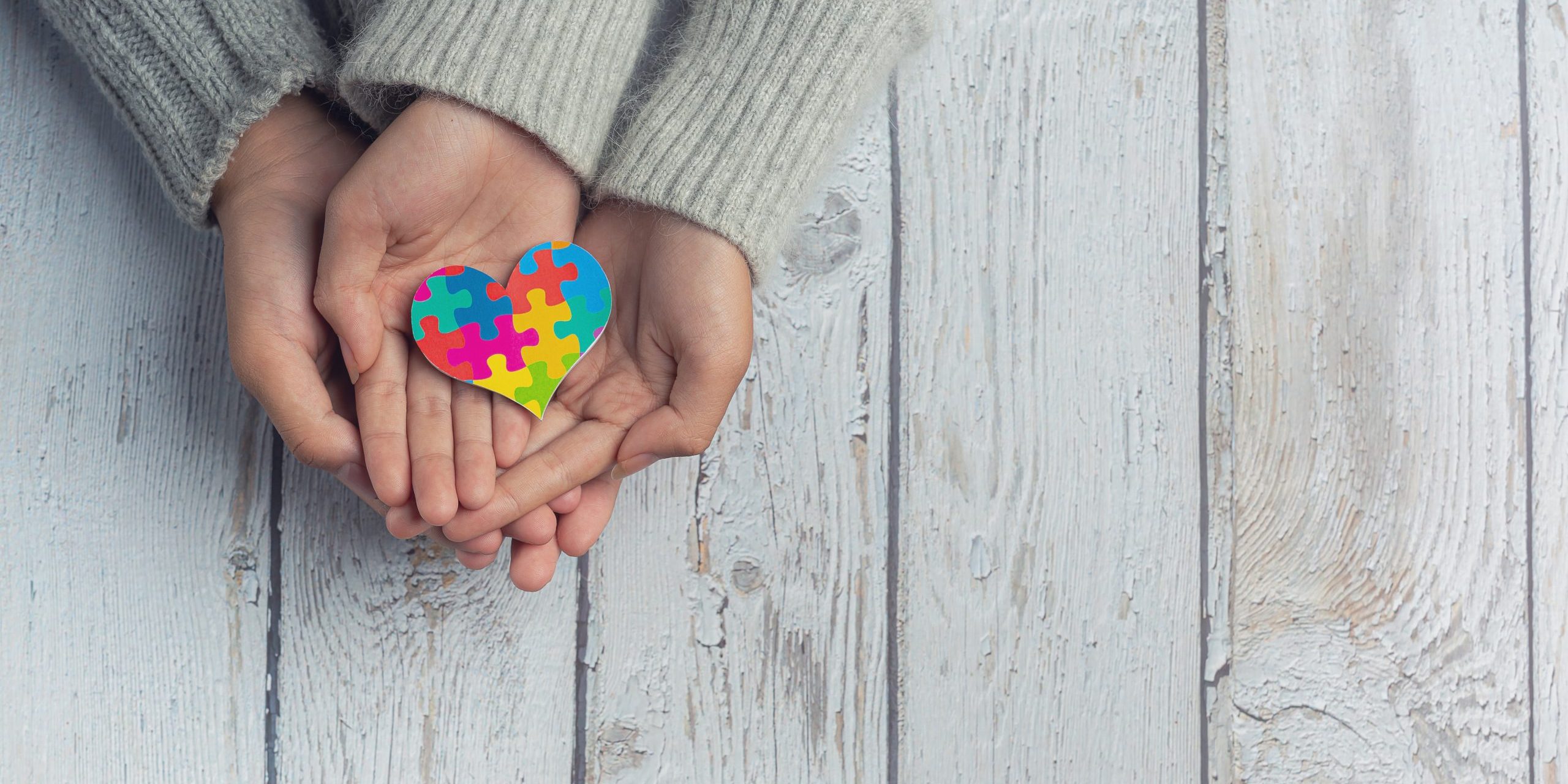 Closeup on two young lovers holding hands at a table.