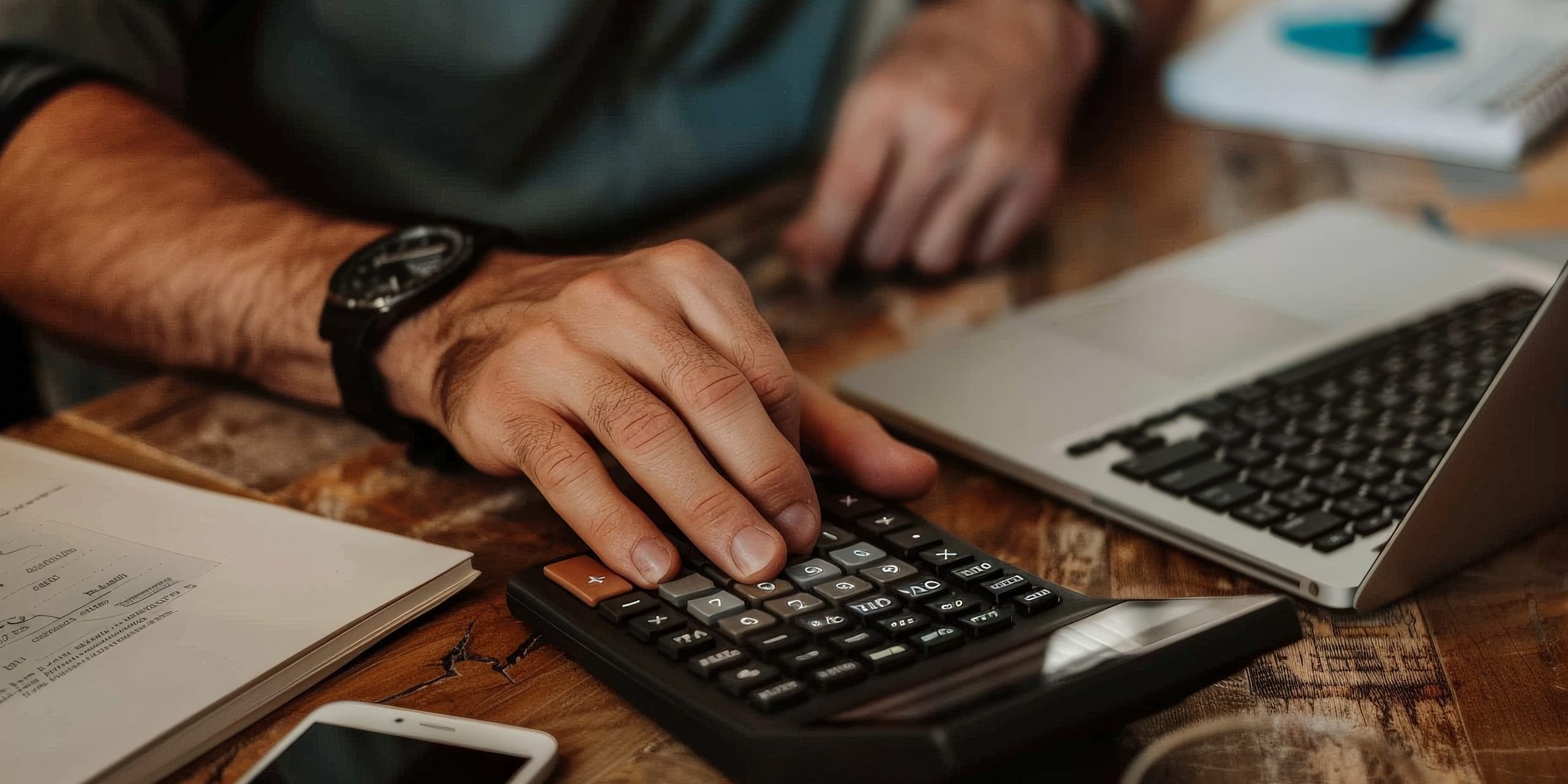 Person using a financial calculator, planning their savings and investments